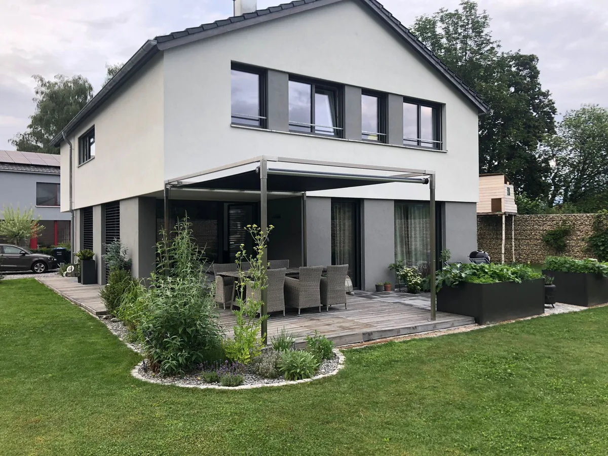 SHADE CUBE auf der Terrasse eines modernen Einfamilienhauses, Membrane ausgefahren über der Sitzgruppe